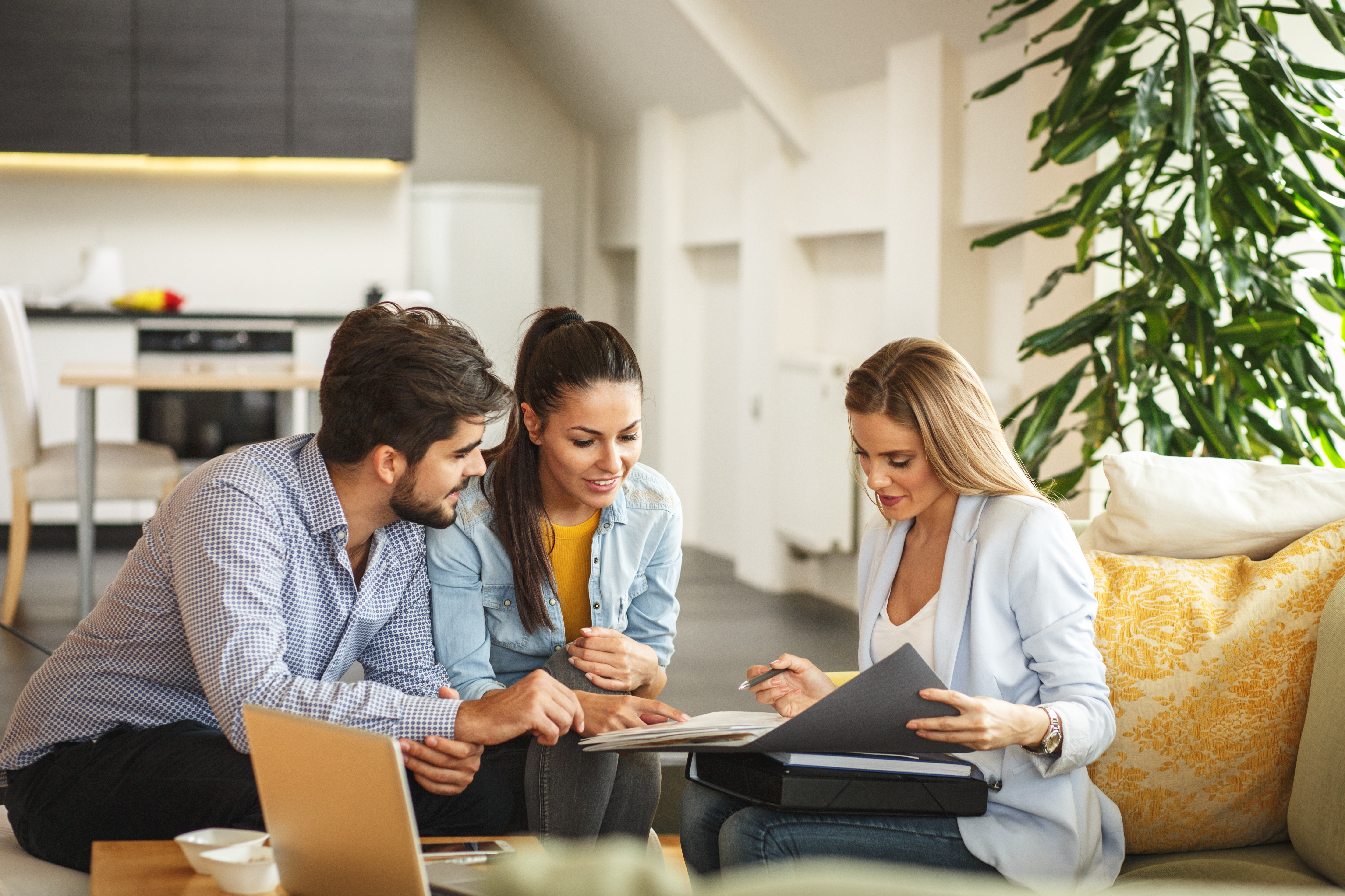 Female real estate agent offering home ownership to a young couple