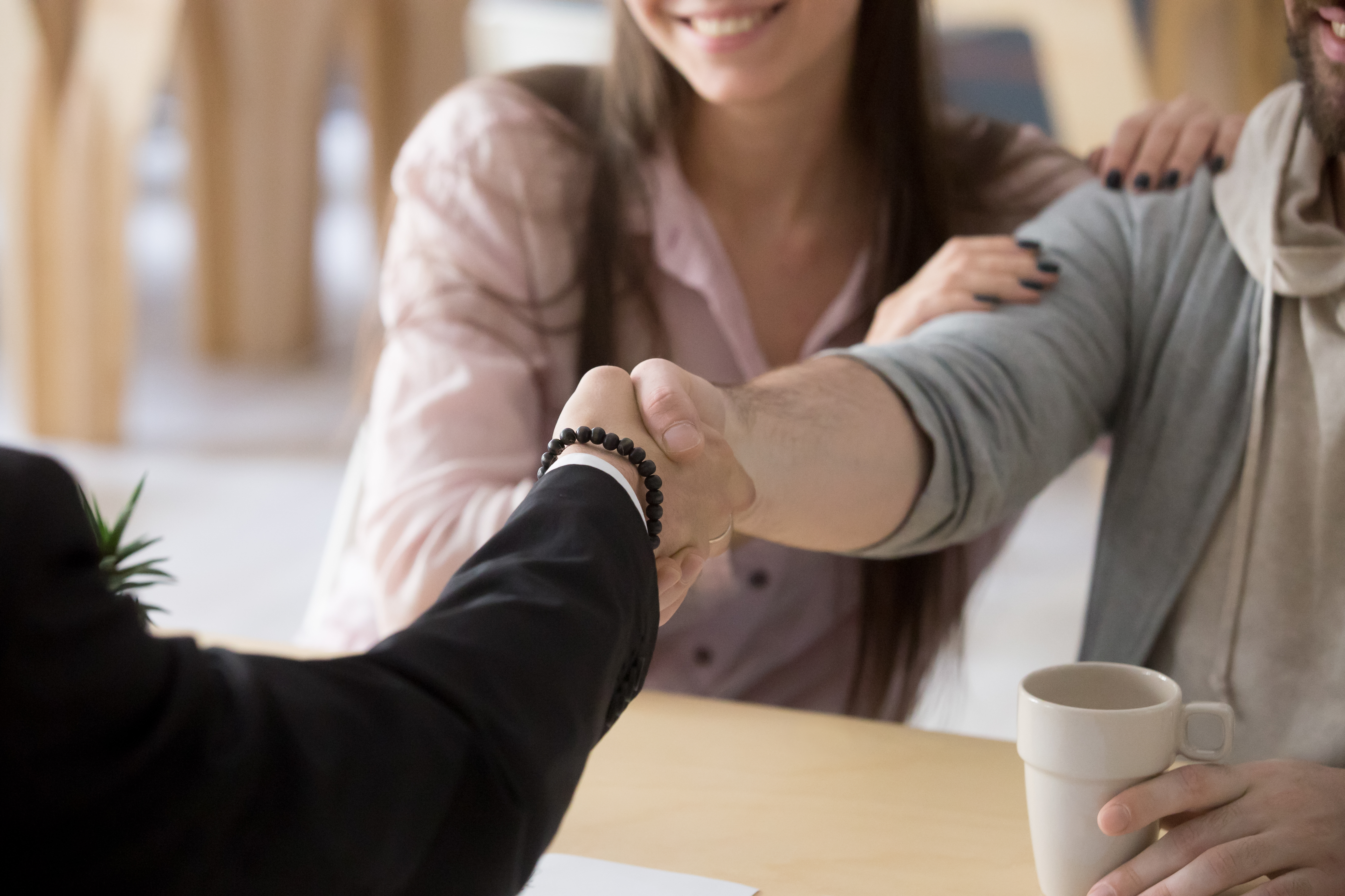 Couple shaking hands with a real estate agent